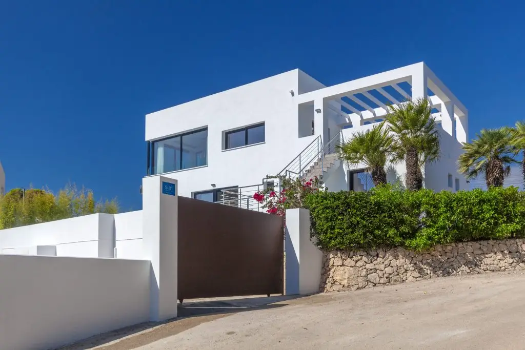 Exterior of a modern gated white box house in Javea, Alicante, Spain