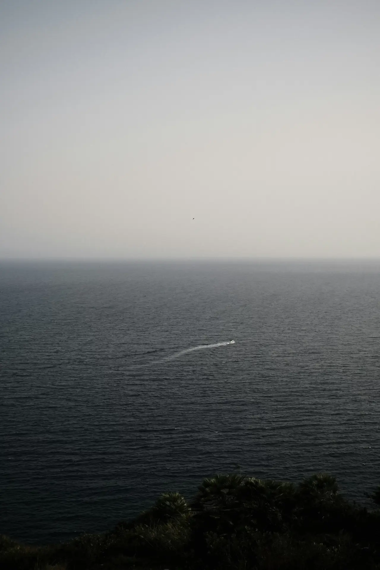 Calm, minimalist sea view with a distant boat wake, evoking the serene Mediterranean coast of Javea.