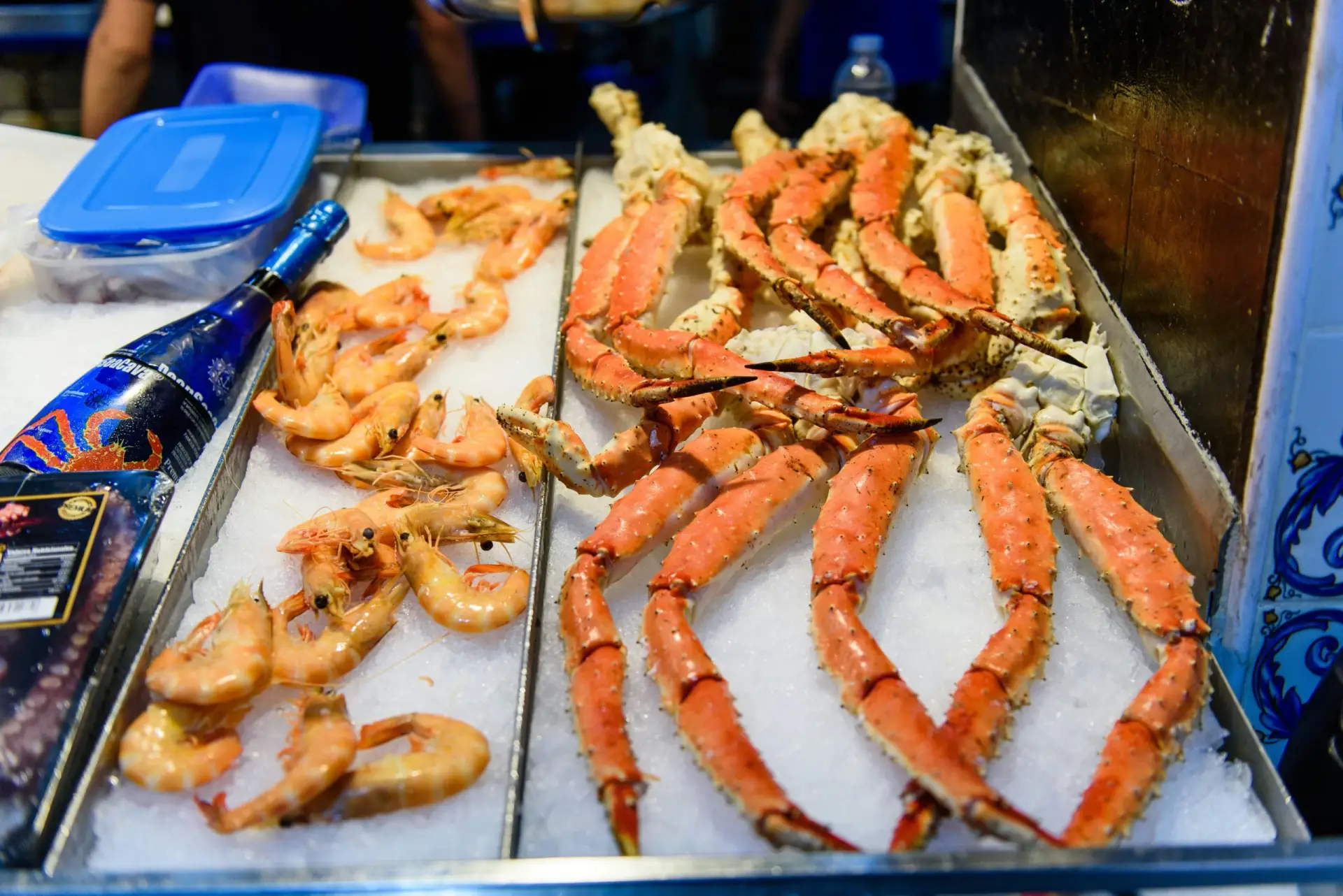Fresh seafood display at Javea's Mercado Municipal, featuring king crab legs and prawns on a bed of ice.
